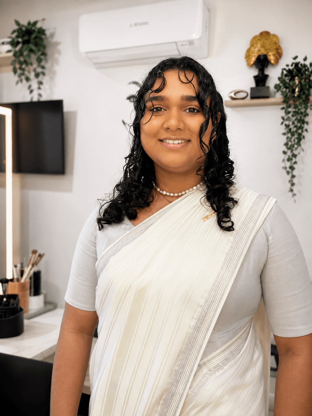 Special-occasion makeup and styling with a cream saree and pearl necklace